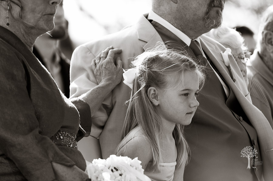 Flower girl watching the wedding ceremony. Mother of the Bride is resting her hand on the shoulder of the father of the bride. Austin Wedding Photography, black and white photography, fine art,
