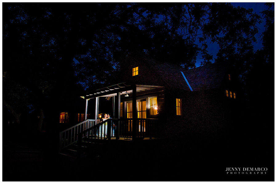 The newly weds swing on a porch together at night. 