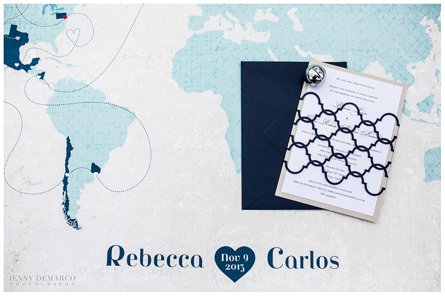 Blue wedding stationary placed over a world map.