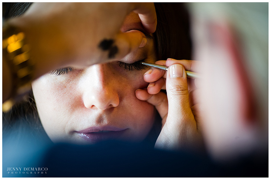 Avery Allen putting eye makeup on the bride. 