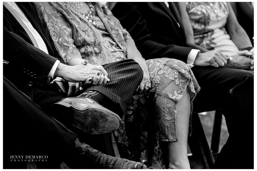An elderly couple is holding hands while the officiate asks for everyone to renew their vows. 