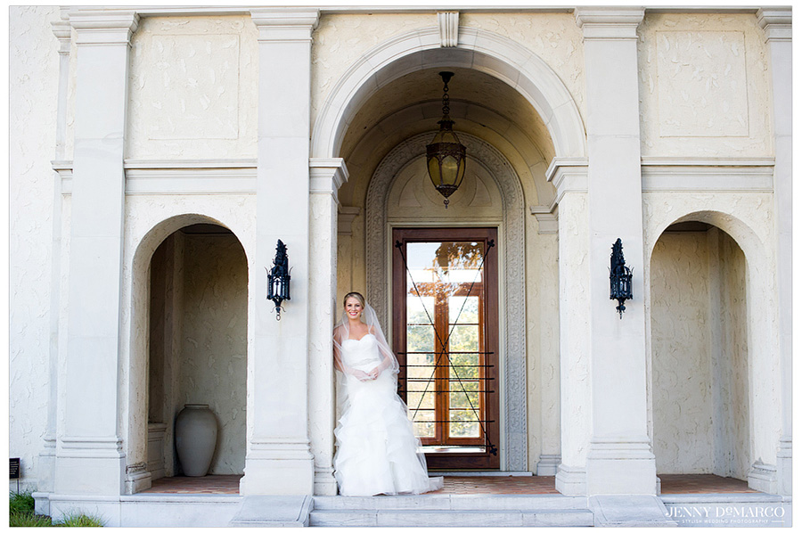 Bride standing in the front of the stone archway of the Italian country villa.