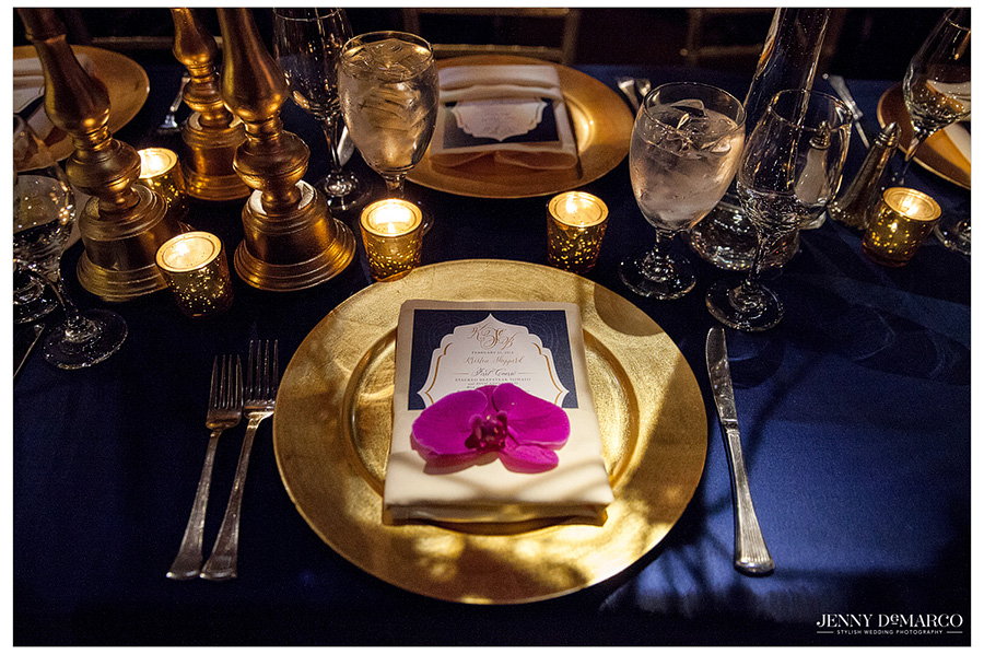 Wedding photographer perfectly captures the gold and fuchsia details of a glamorous wedding reception. 