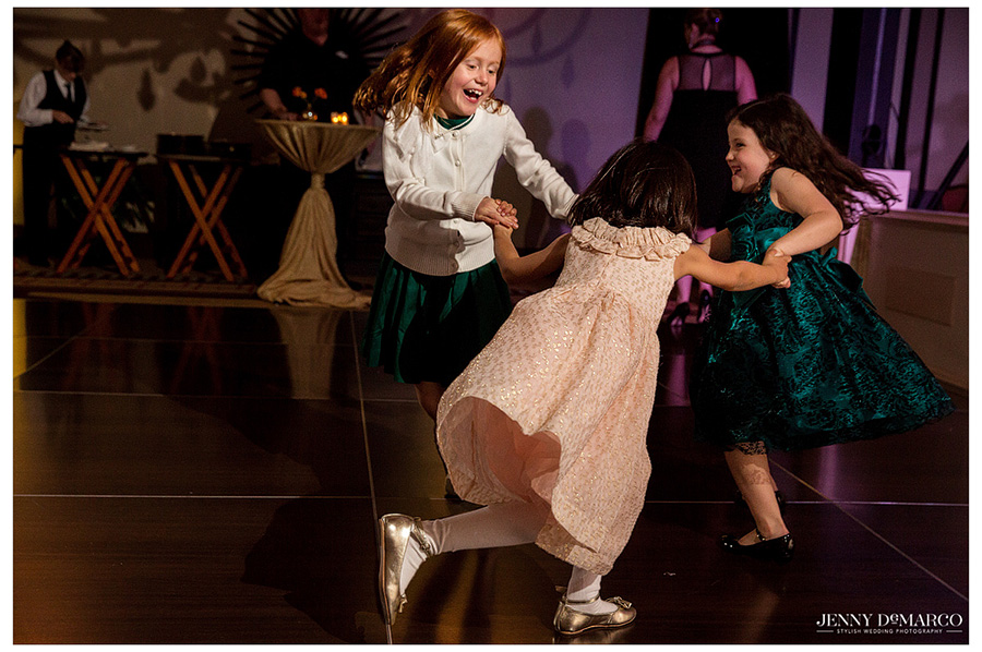 Children laughing and dancing on the dance floor at wedding reception 