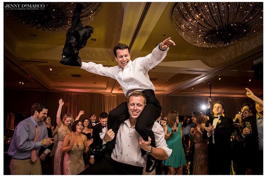 A friend hops on the shoulders of another guest for a picture as the reception draws to a close.