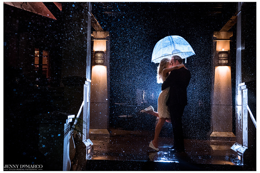 The bride and groom share one last kiss in the rain before jumping in their getaway car.