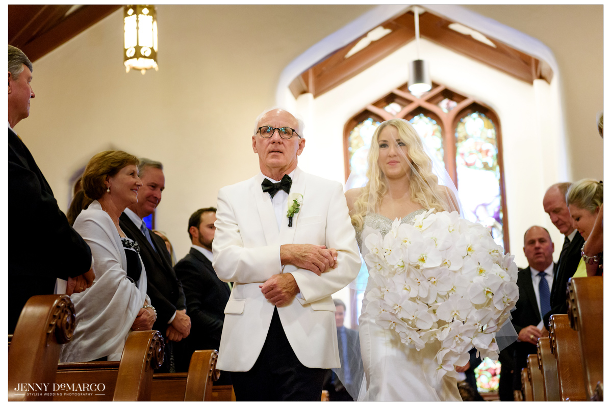 The bride's father walks his daughter down the aisle before giving her away.