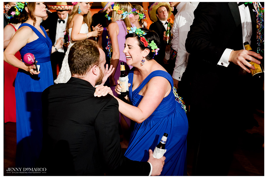 Wedding guests laugh and dance at the reception. 
