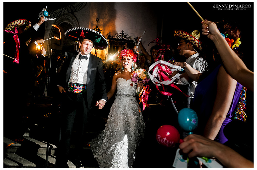 The bride and groom, wearing a floral wreath and sombrero, together at the wedding reception. 