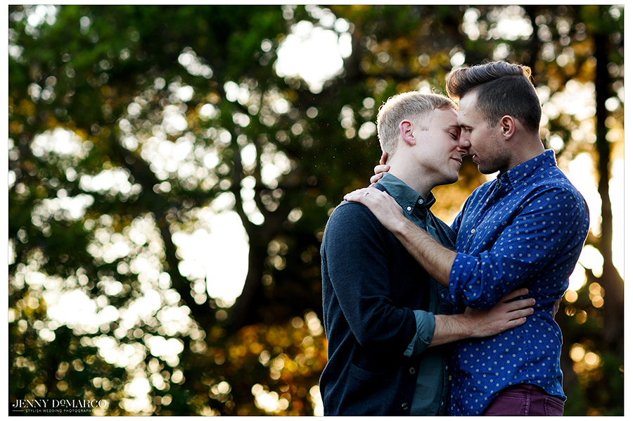 Austin gay couple kissing with sunlight through trees
