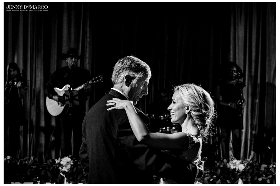 Black and white photo of the bride and her father sharing a dance at the wedding reception. 