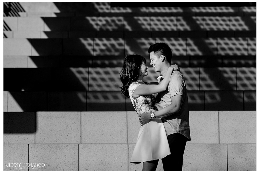Unclose shot of couple with their arms around one another on the steps of Austin city hall as the laugh, shot in black and white