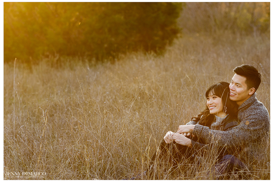 second photograph of the couple looking at the sunset while lying in a field and smiling