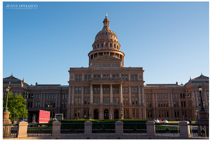 View of the Texas State Capitol building from the Northside lit by the sun on the right. 