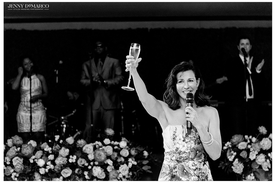 Brides mother gives a toast with her champagne glass held high 