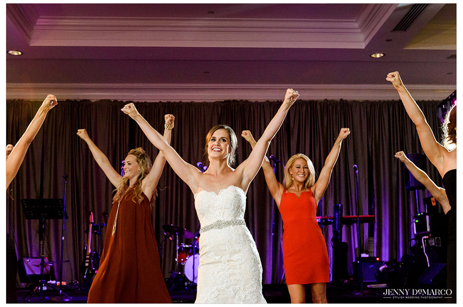The bride and her friends perform a University of Texas Pom routine on stage for their guests.