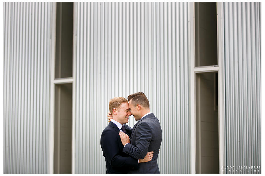 Grooms embrace during first look.