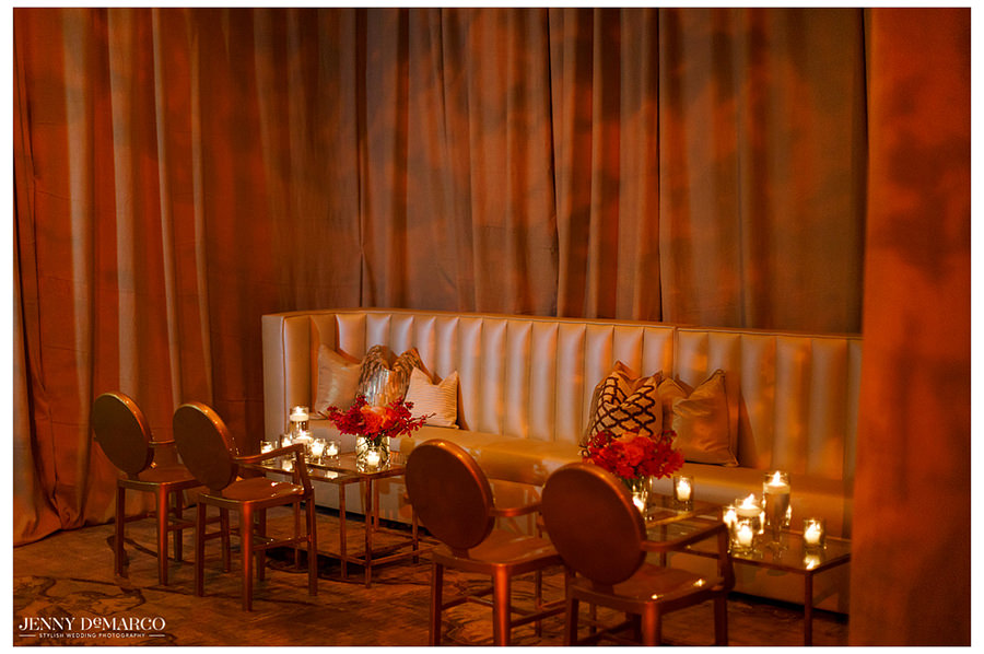 A rose gold and champagne side seating area decorated with candles and flowers awaiting the guests prior to the reception.