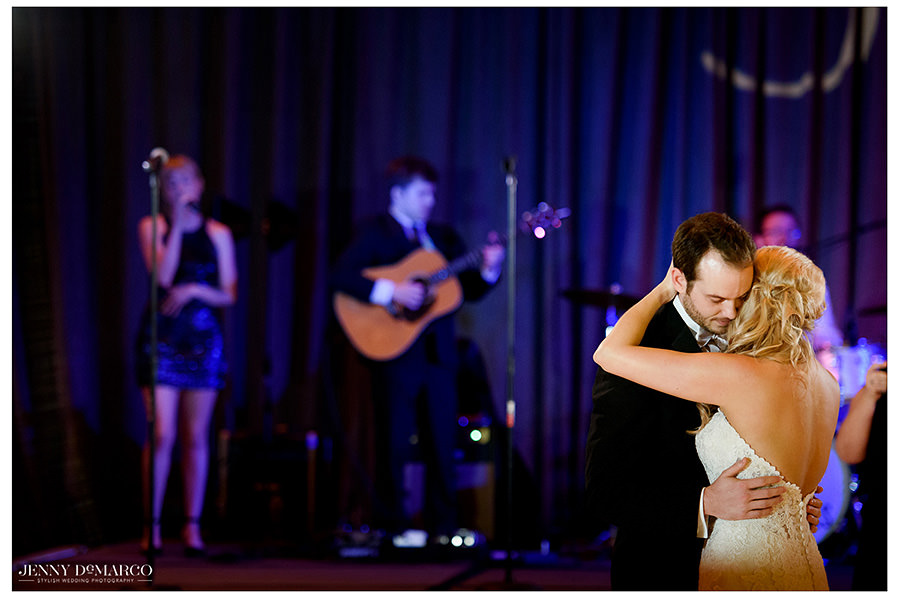 The bride and groom with the band behind them during their first dance.