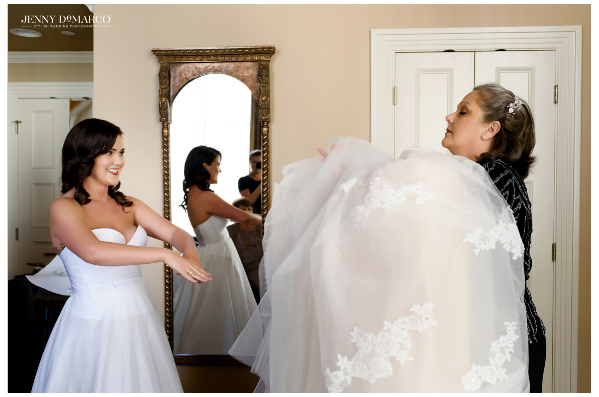 Mother of the bride helping her daughter into her dress.
