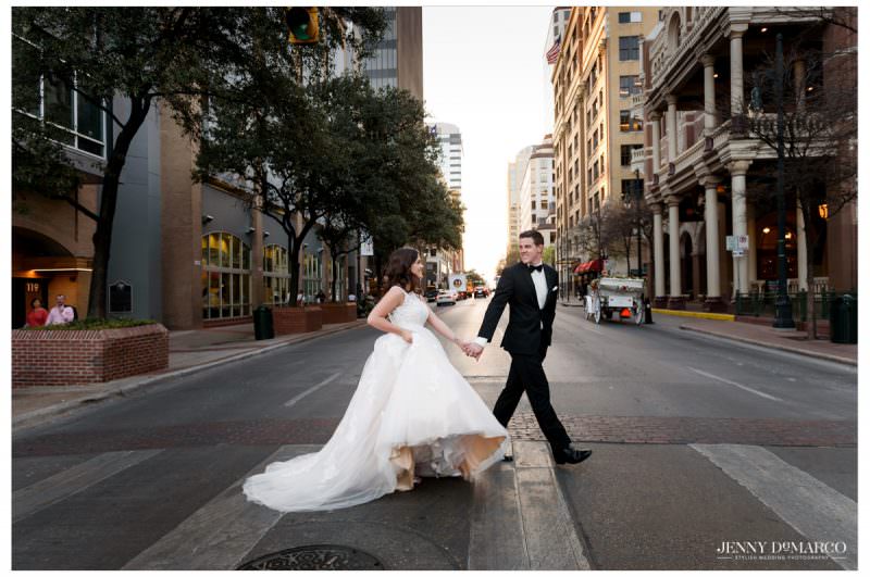 Bride and groom crossing downtown Austin near The Driskill Hotel during wedding portraits