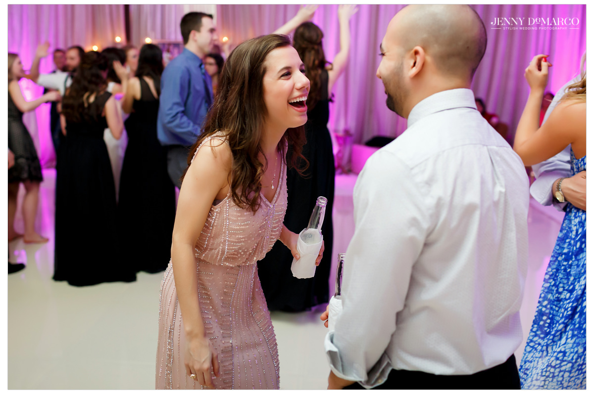Guests laughing and talking at the wedding reception.
