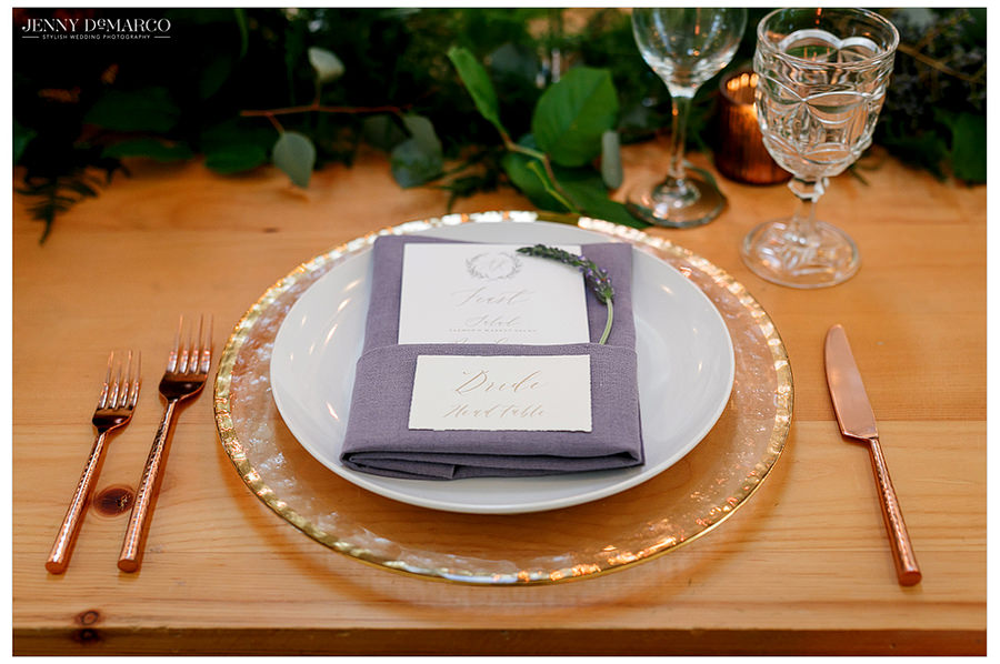 A close up of the place settings at the main dining table complete with menu and name card.