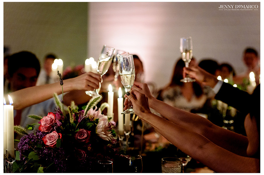 A champagne toast being lifted up in celebration of the bride and groom.