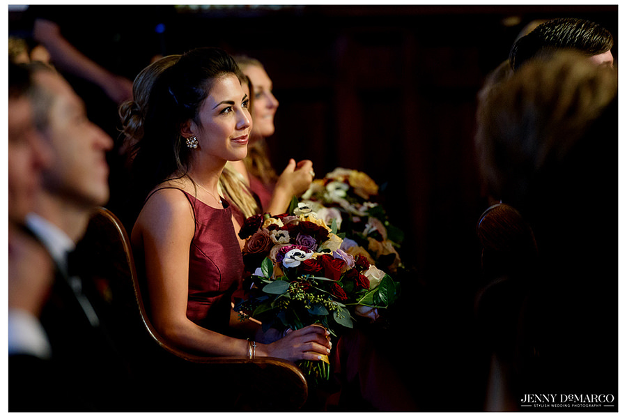 Bridesmaid looking on intently during wedding ceremony.