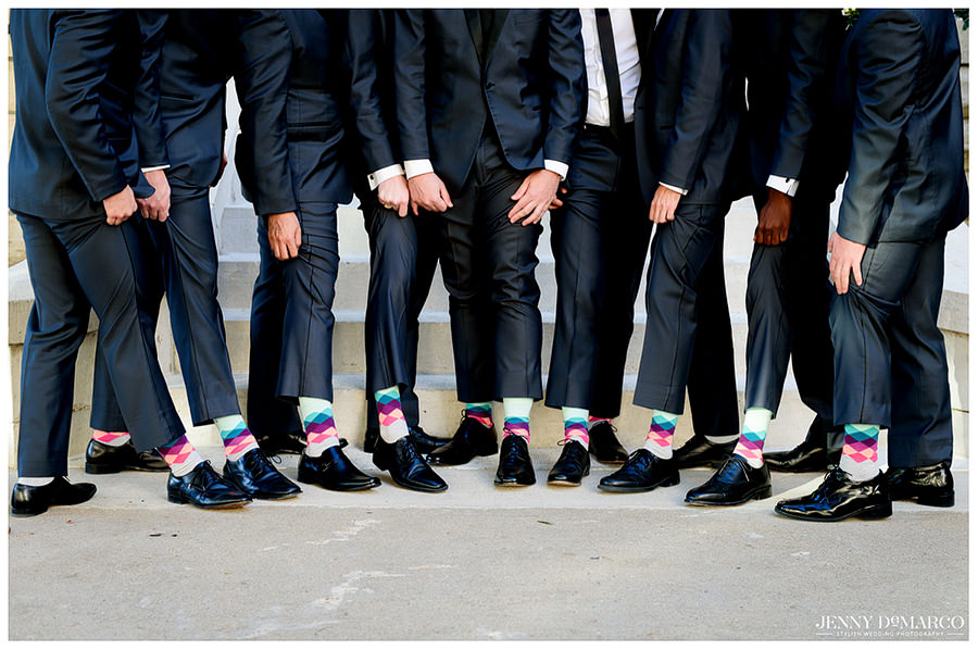 Silly photo of groom and groomsmen showing their matching silly socks at the wedding venue