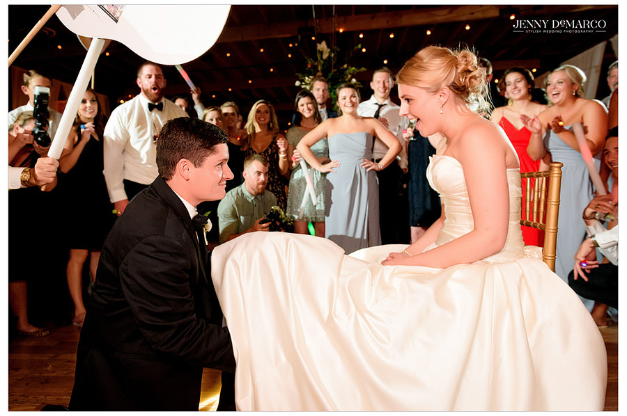 Groom removes garter from bride at wedding