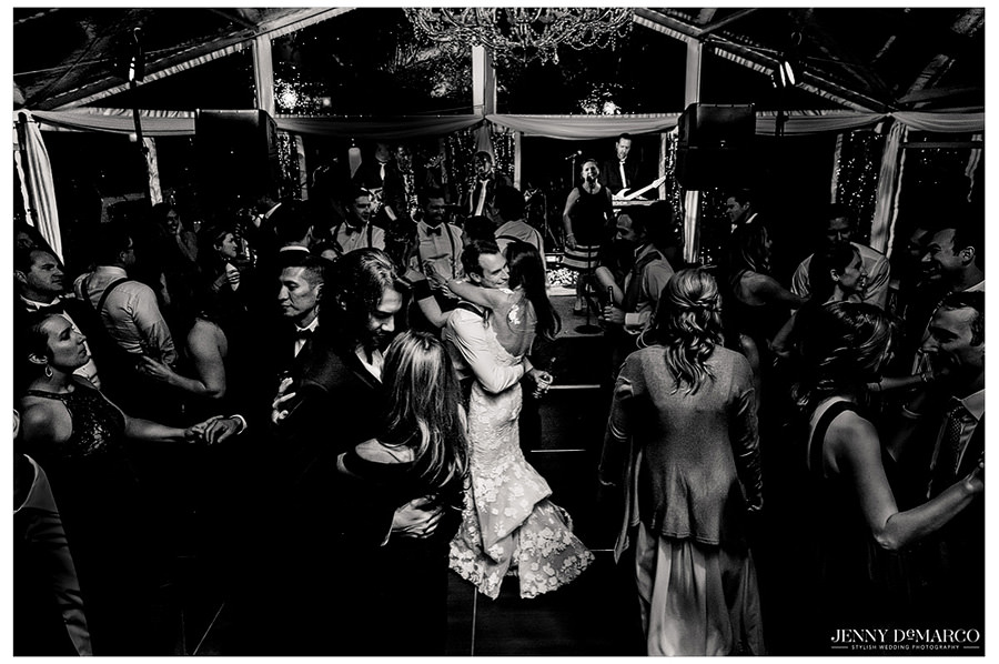 Bride and groom embrace in the middle of the dance floor. 