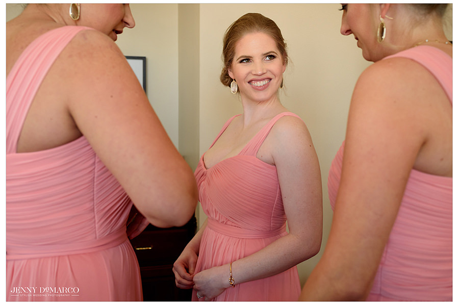 the pink bridal party laugh as they get ready for the big day