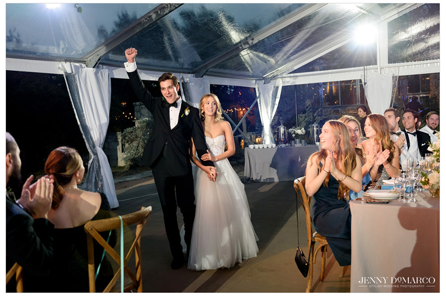 groom cheers in excitement as they enter the hill country reception 