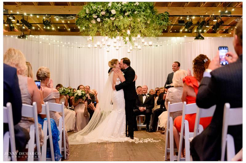 Bride and groom share their first kiss as a married couple. 
