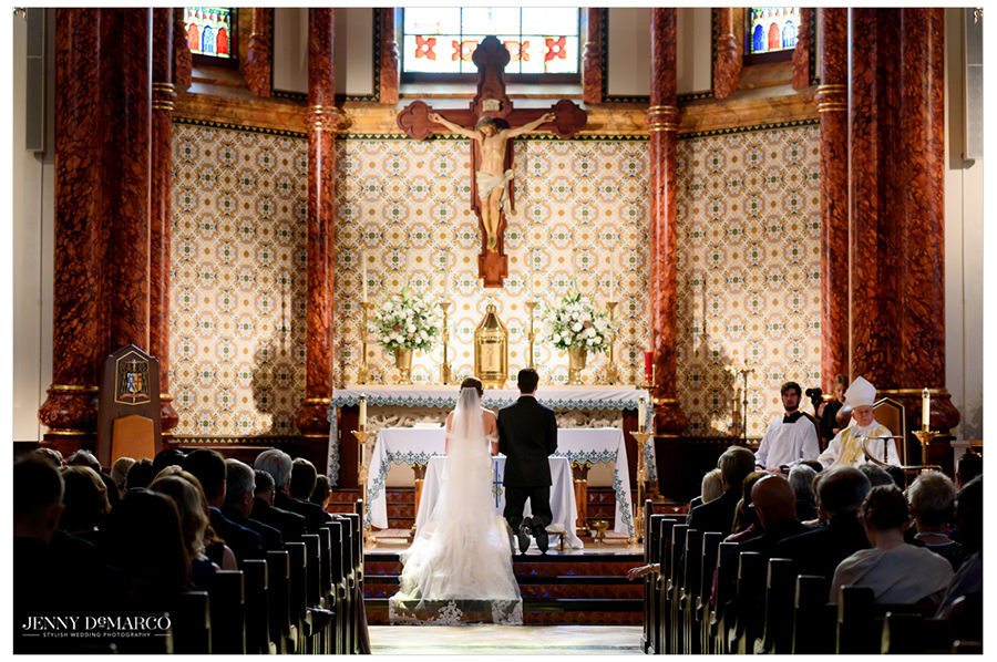 Bride and groom kneel before the altar.