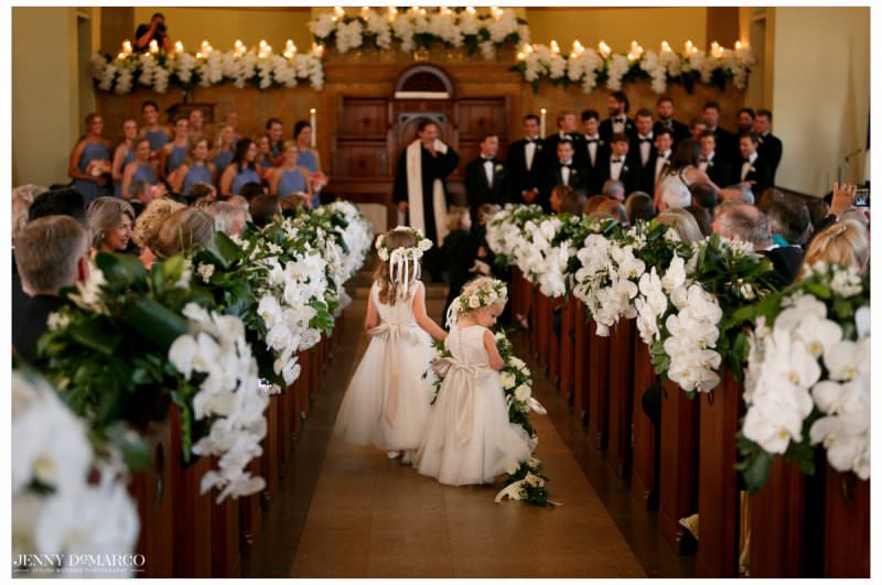 Flower girls line the aisle with rose petals.