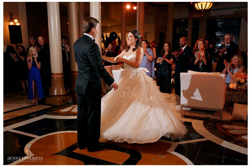 The groom twirls his bride.