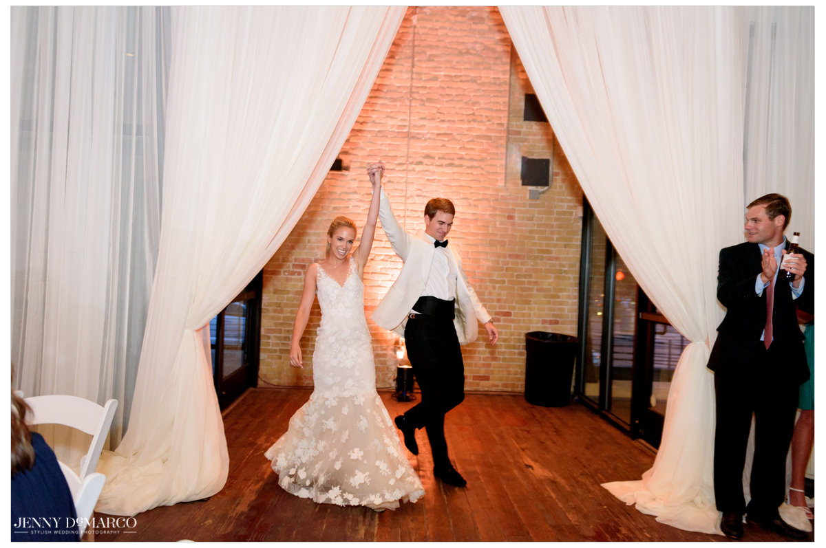 The couple enter the reception as guests cheer. 