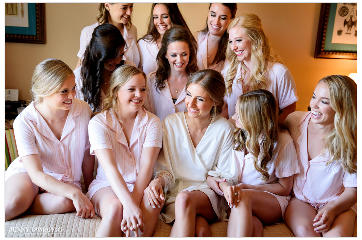 All the bridesmaids gather around the bride to pose for a photo.