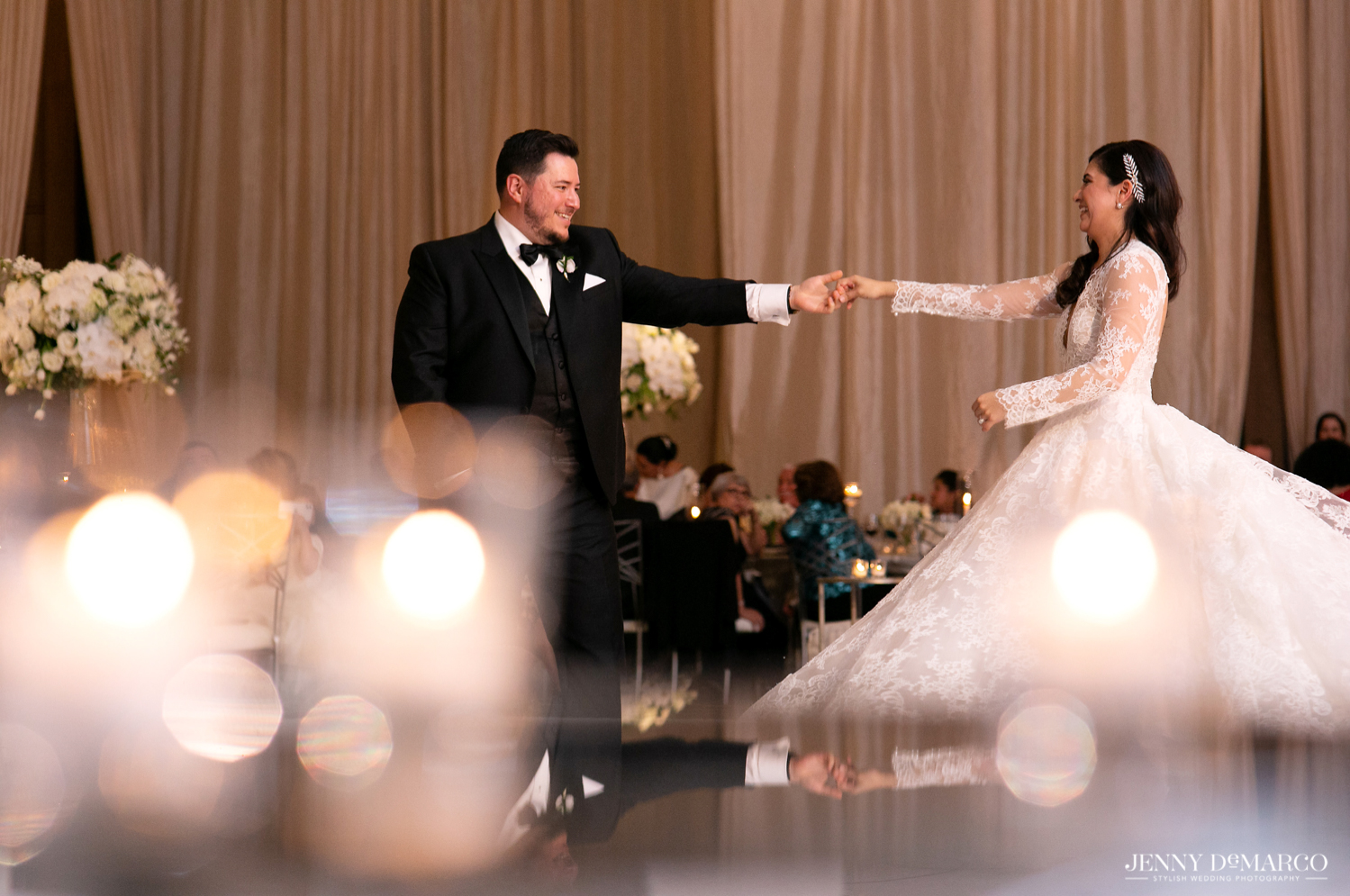 groom twirling his bride on the dance floor 