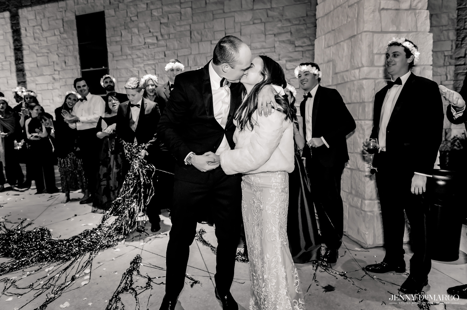 Bride and groom share a kiss as they leave reception