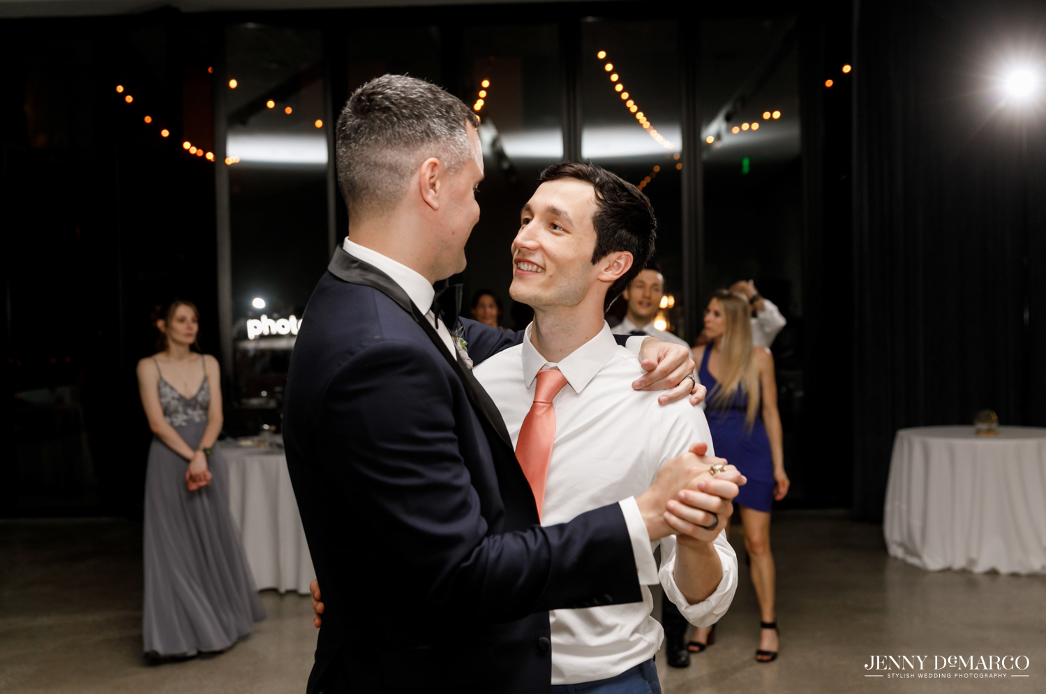 Grooms slow dancing during reception