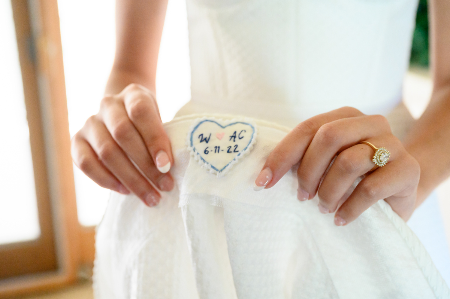 embroidered heart with the bride's and groom's initials on the inside of the brides wedding dress 