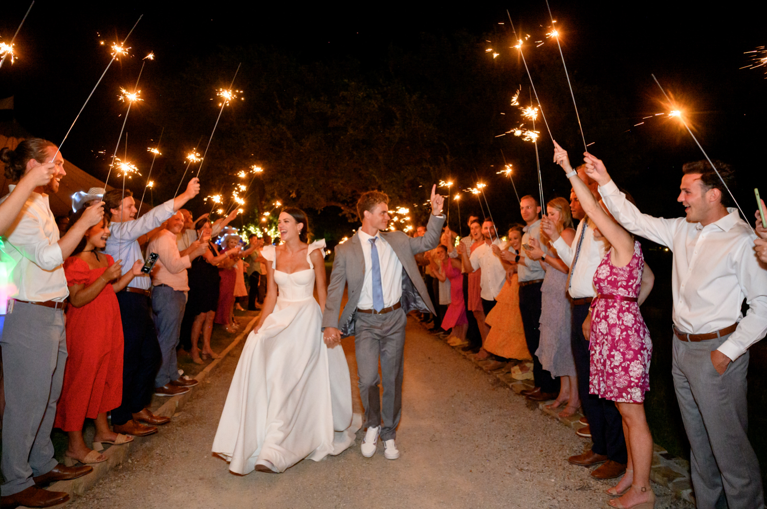 bride and groom exit while gusts hold up sparklers 