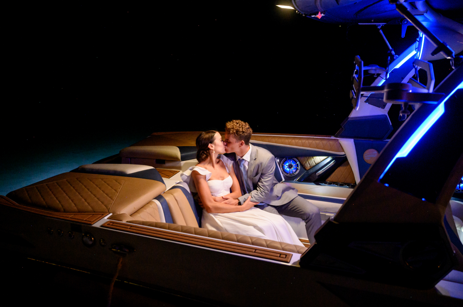 bride and groom kiss on their exit boat 