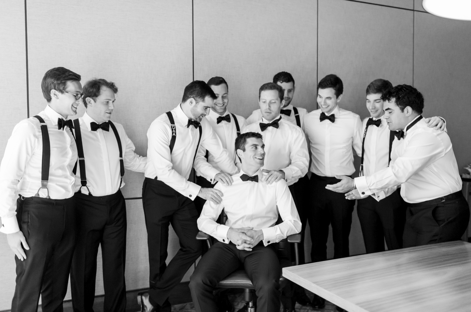 Groomsmen stand behind and around the groom and hype him up