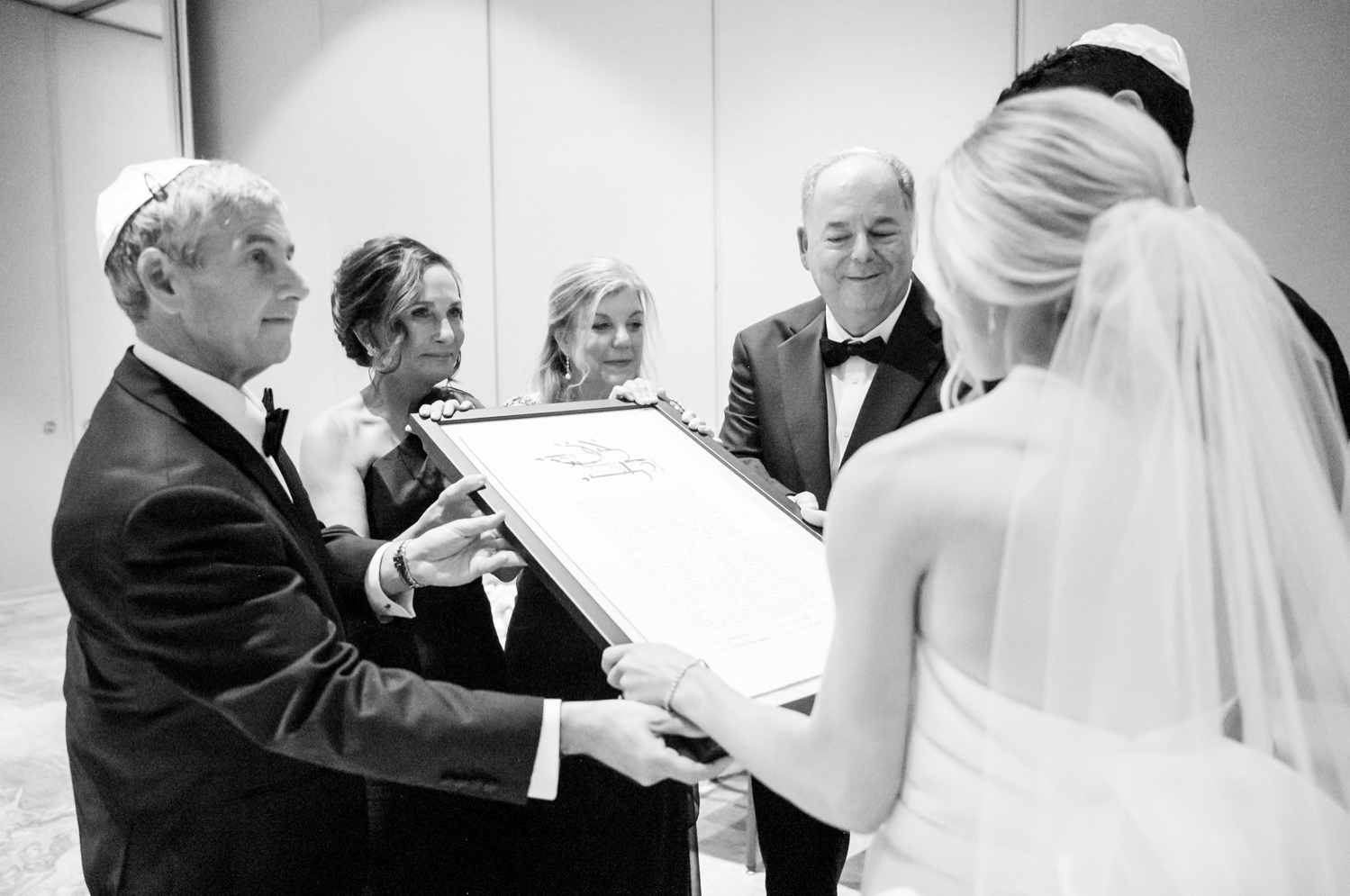 The bride and groom's family presents the signed ketubah to them