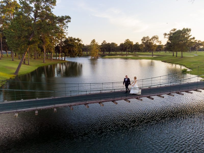 Bride and groom walking beside the lake at Lakeside Country Club during their Houston wedding