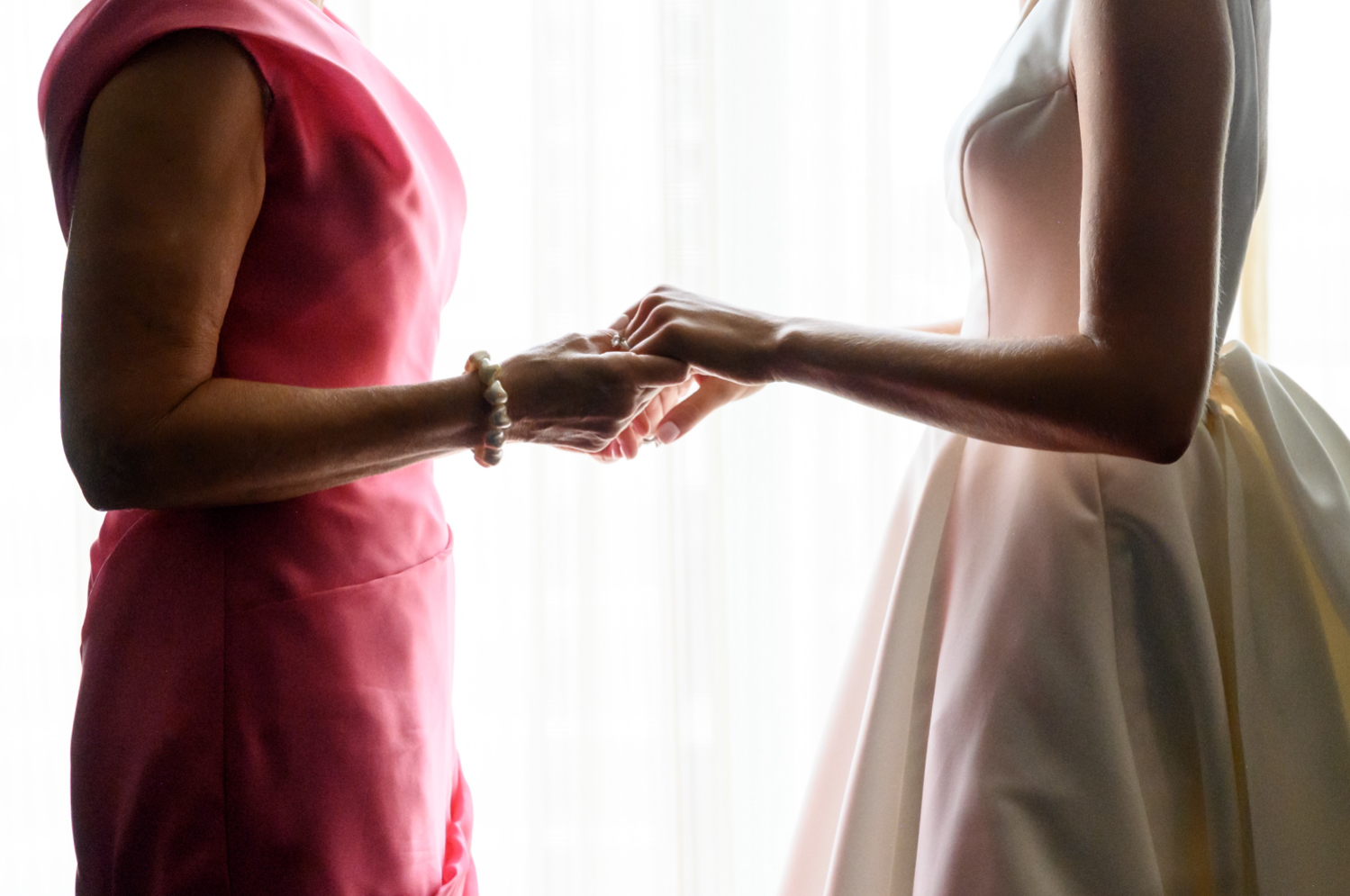 bride and her mother holding hands before wedding 